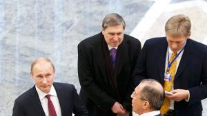 Russian President Vladimir Putin (L) stands with Foreign Minister Sergei Lavrov (R, front) and Kremlin spokesman Dmitry Peskov (R, back) after peace talks on resolving the Ukrainian crisis in Minsk, February 12, 2015. The leaders of Germany, France, Russia and Ukraine have agreed a deal to end fighting in eastern Ukraine, participants at the summit talks said on Thursday.    REUTERS/Vasily Fedosenko (BELARUS  - Tags: POLITICS)